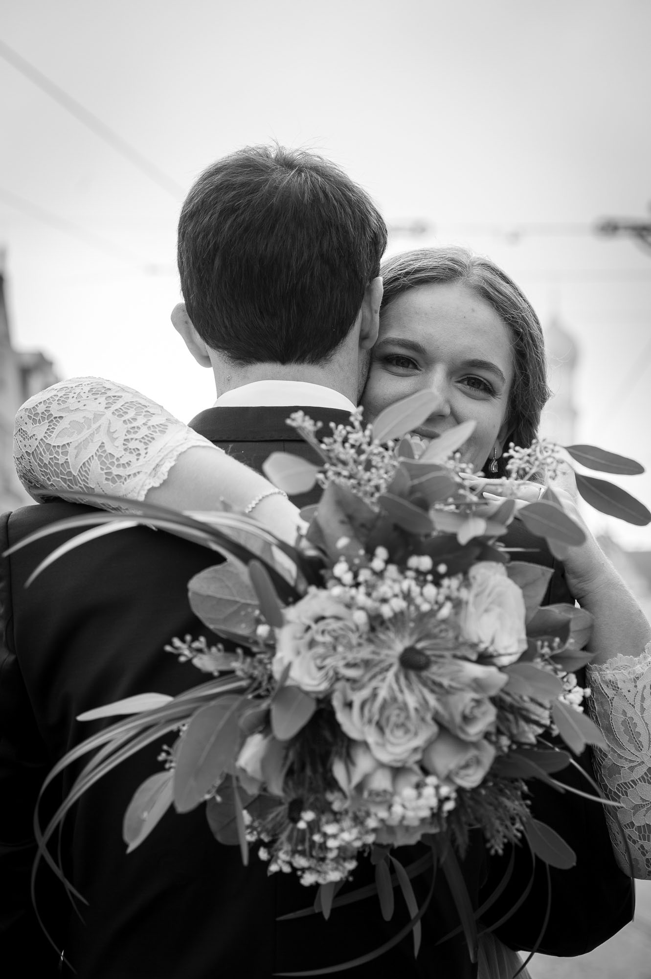 Emotionale Umarmung – Braut blickt über Schulter des Bräutigams bei Hochzeit in Augsburg