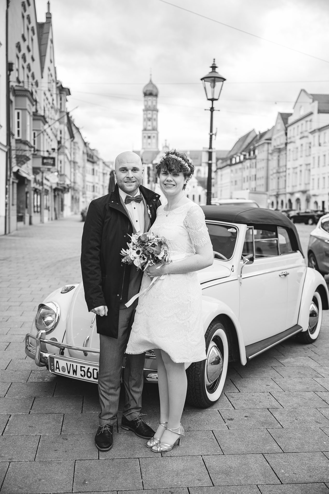 Brautpaar vor dem Brautauto vor dem Standesamt in Augsburg
